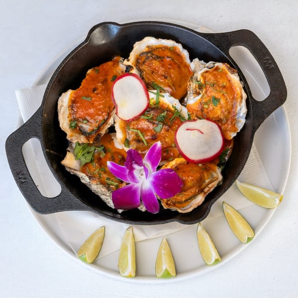 Mi Cava & Cocina's baked oysters with red sauce, radishes, cilantro, and a purple orchid.