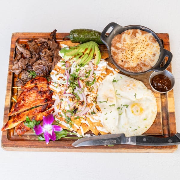 Mi Cava & Cocina's Mexican platter with steak, chicken, chilaquiles, fried eggs, and refried beans.