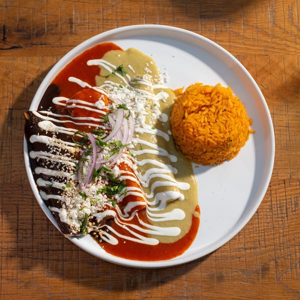 Mi Cava & Cocina enchiladas with red, green, and mole sauces, rice, cheese, and onions.