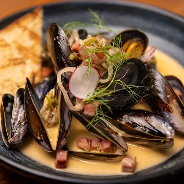 Mi Cava & Cocina's mussels in a creamy sauce with radishes, dill, and toasted bread.