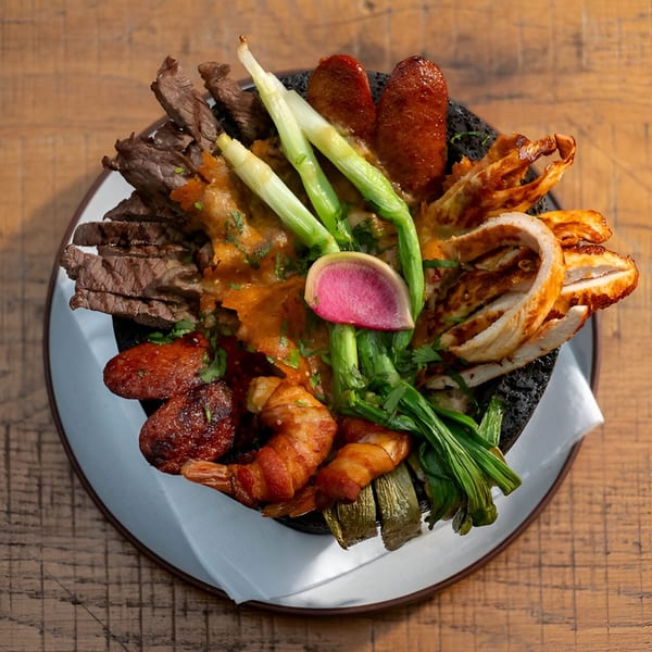 Mi Cava & Cocina's Mexican molcajete with steak, chicken, chorizo, shrimp, green onions, and radish.